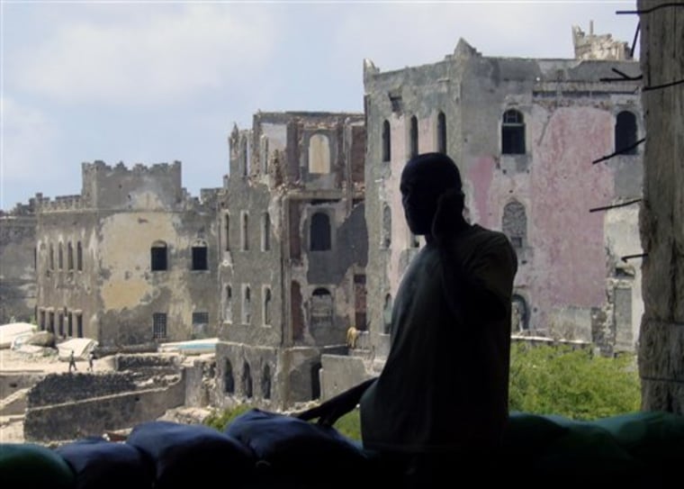 In this Friday Sept. 1, 2010 photo, an African Union soldier takes a call in front of a row of ruined, bullet-scarred buildings near the Somali sea front in Mogadishu. Many buildings have been reduced to rubble by the fighting. Most Somalis, battered by two decades of war and seeing no improvement in their lives, have lost faith in their government.(AP Photo/Katharine Houreld)